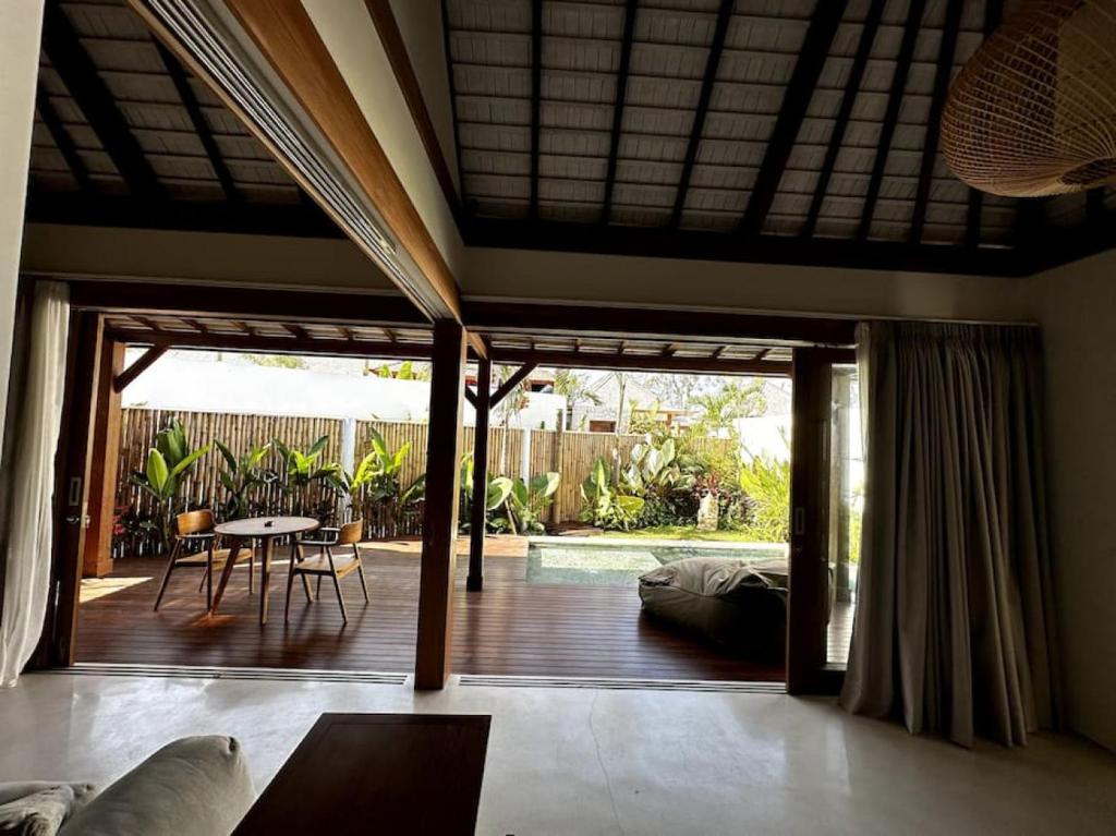 een woonkamer met een patio met een tafel en een zwembad bij Di Cappio Studio Uluwatu in Uluwatu