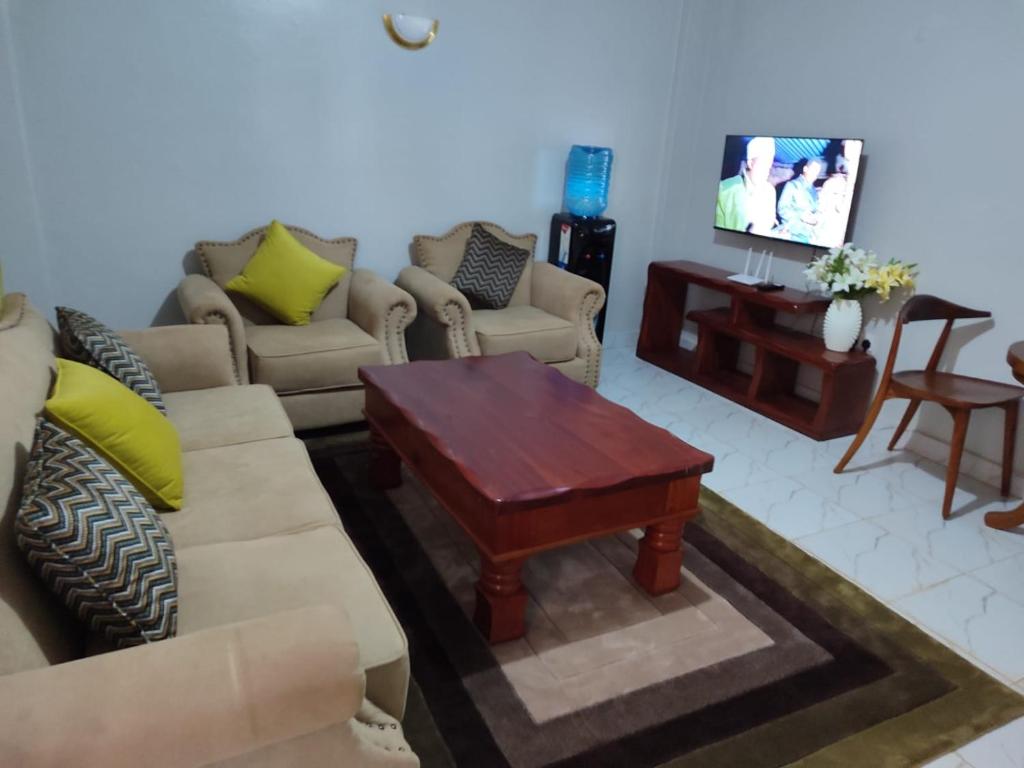 salon z kanapą i telewizorem w obiekcie The Nest Githunguri w mieście Kamondo