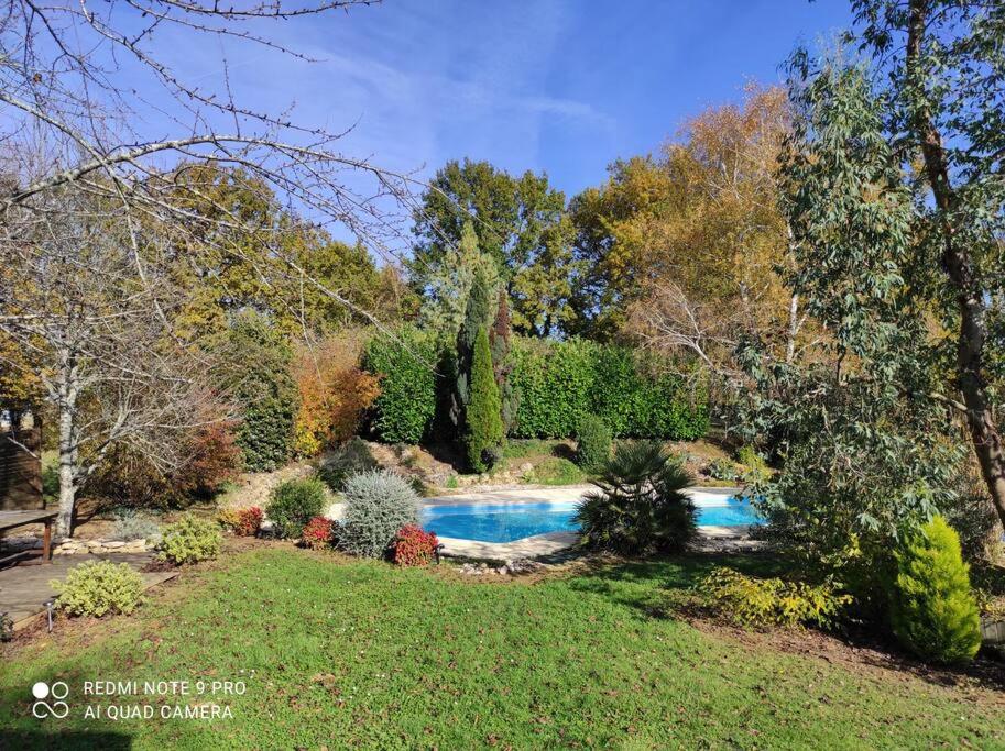 einen Garten mit Pool im Hof in der Unterkunft Haut de villa : véranda, terrasse, vue piscine in Thiviers