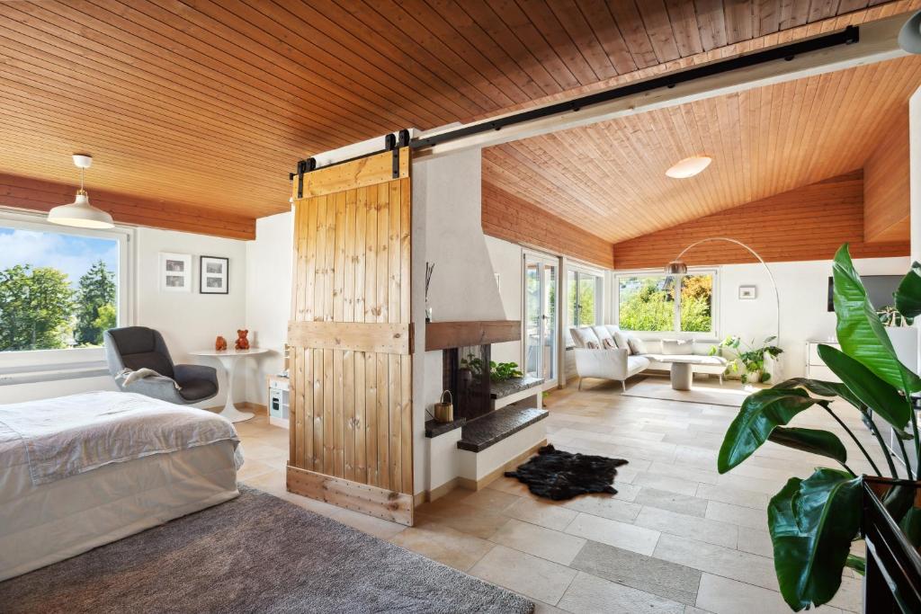 a bedroom with a fireplace in the middle of it at Luxus Loft am Zürichsee I Seesicht I Garten I Arbeitsplatz in Richterswil