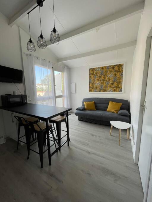 un salon avec une table et un canapé dans l'établissement T2 Familiaux - Confort & Plage à Pied, à Saint-Cyprien