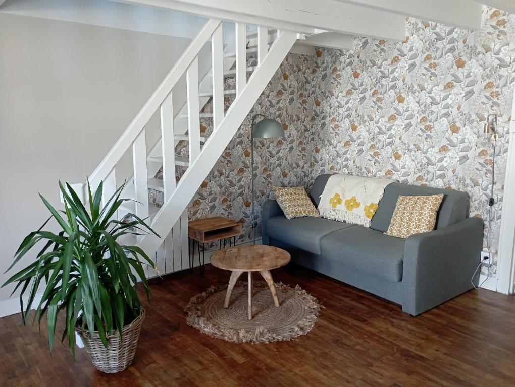 a living room with a couch and a stair case at LA PETITE BRETONNE in Noyal-Muzillac