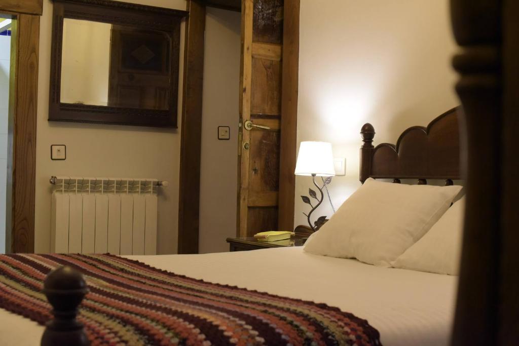 una camera da letto con un letto grande con testiera in legno di Habitaciones - La Pumarada de Limés II a Cangas del Narcea
