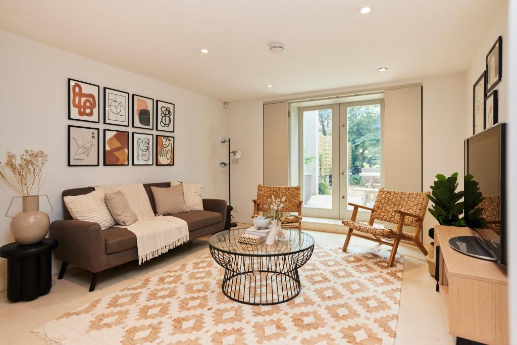uma sala de estar com um sofá e uma mesa em The Brimmington Park Escape - Lovely 3BDR House with Study Room + Garden em Londres