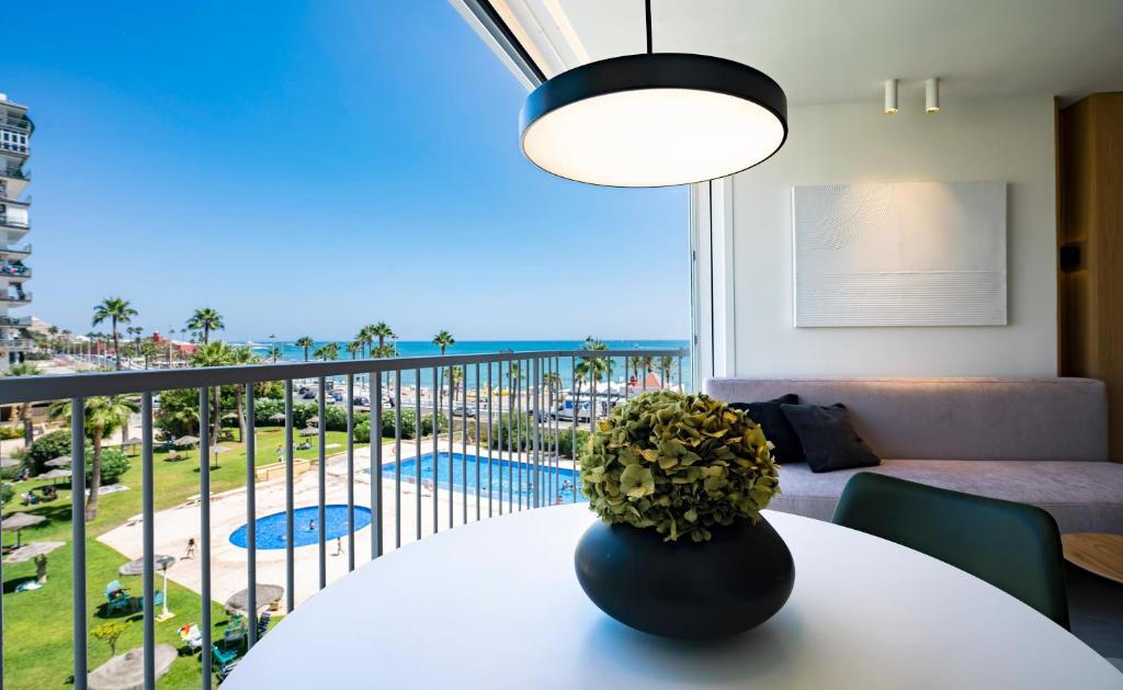 een woonkamer met een tafel en uitzicht op de oceaan bij Apartamentos Los Maites - 1º Linea de Playa - Vista al mar in Benalmádena