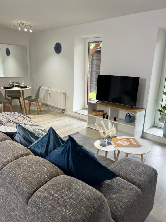 sala de estar con sofá y TV en Home Inn Apartments - 201, en Minden