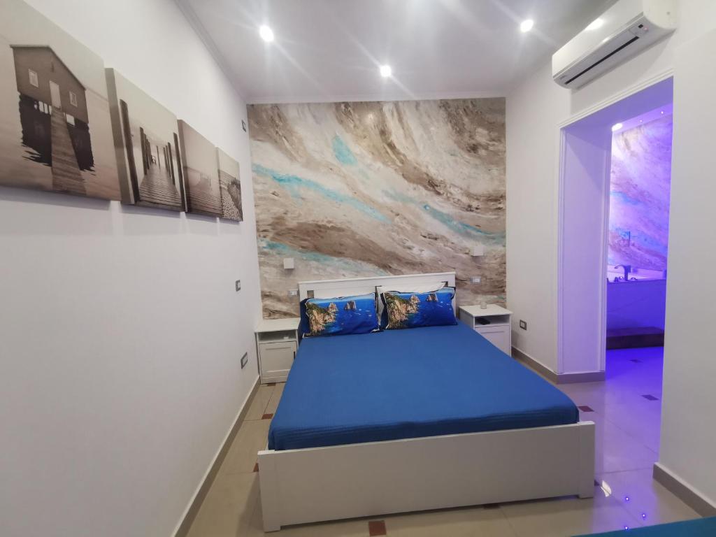 een slaapkamer met een bed en een schilderij aan de muur bij Le Stanze di Eli e Giò in Castellammare di Stabia