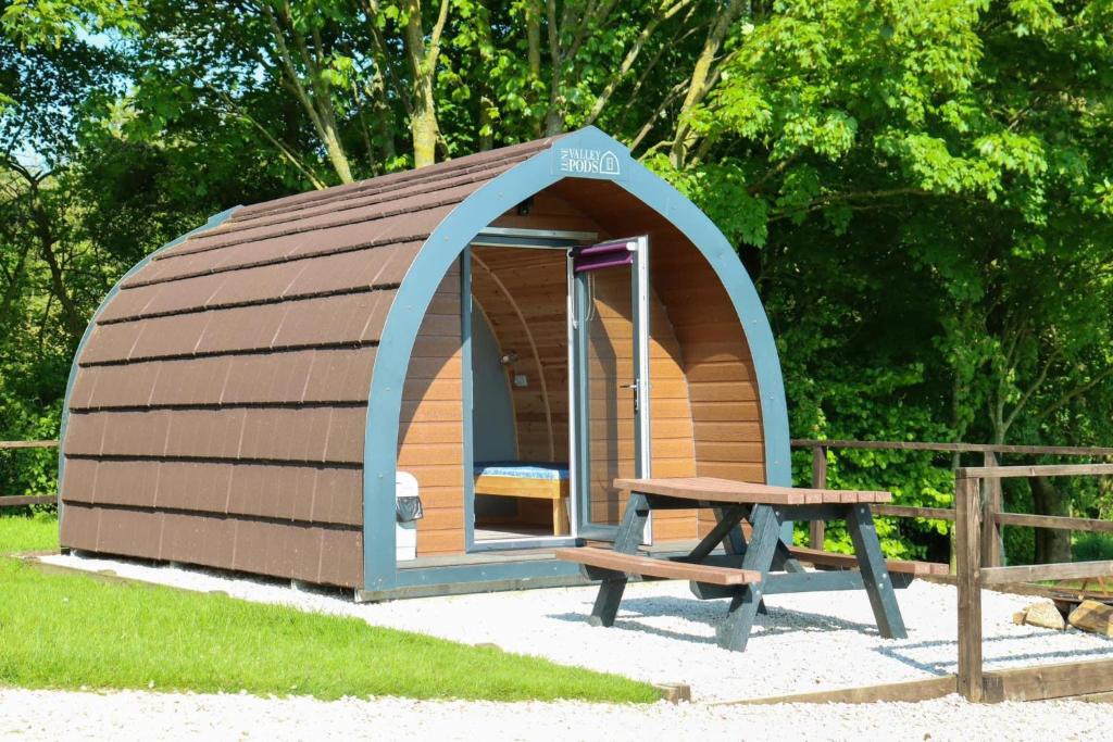 una piccola camera con tavolo da picnic e panca di Wyreside Lakes Glamping Pods a Lancaster