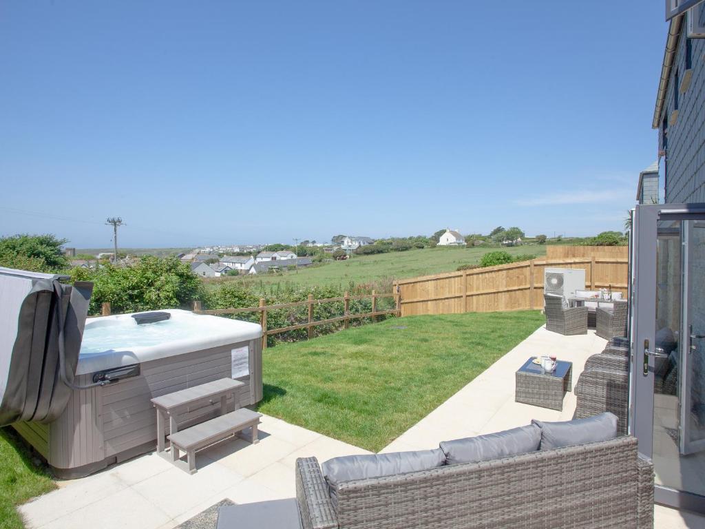 a backyard with a hot tub and a patio at Fox Lodge in Crantock