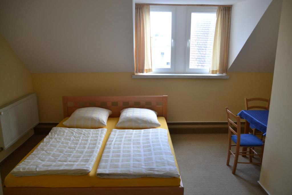 two beds in a small room with a window at Pension Altwahnsdorf in Radebeul