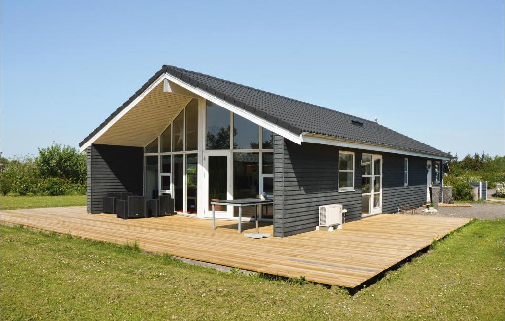 een klein huis met een houten terras in een veld bij Lovely Home In Hemmet With Wifi in Falen