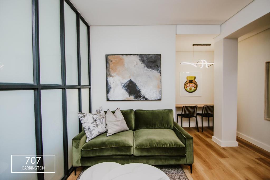 sala de estar con sofá verde y mesa en The Carrington Top Floor Luxury Apartment, en Ciudad del Cabo