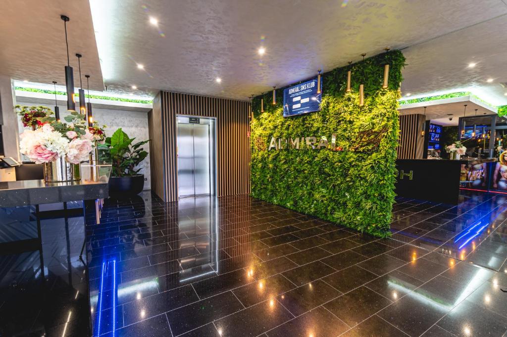 a lobby of a restaurant with a green wall at Casino & Hotel ADMIRAL Ptuj in Ptuj