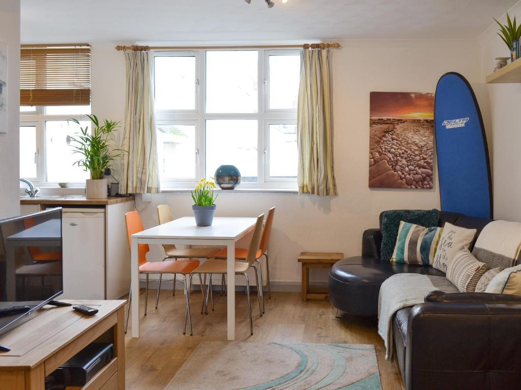 a living room with a couch and a table with a surfboard at The Nook in Woolacombe