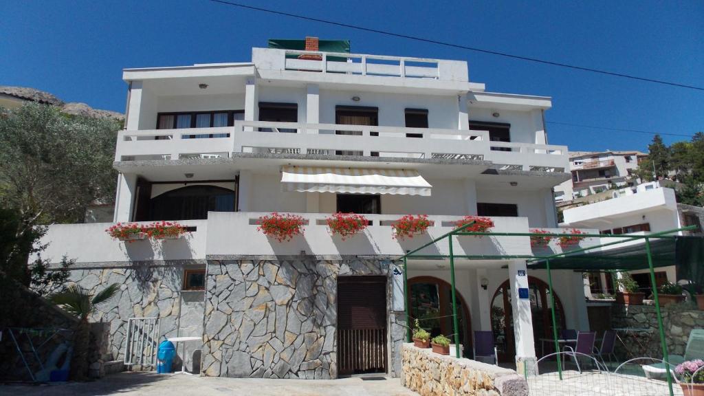 a white building with flowerpots on the front of it at Apartment Batomalj in Baška