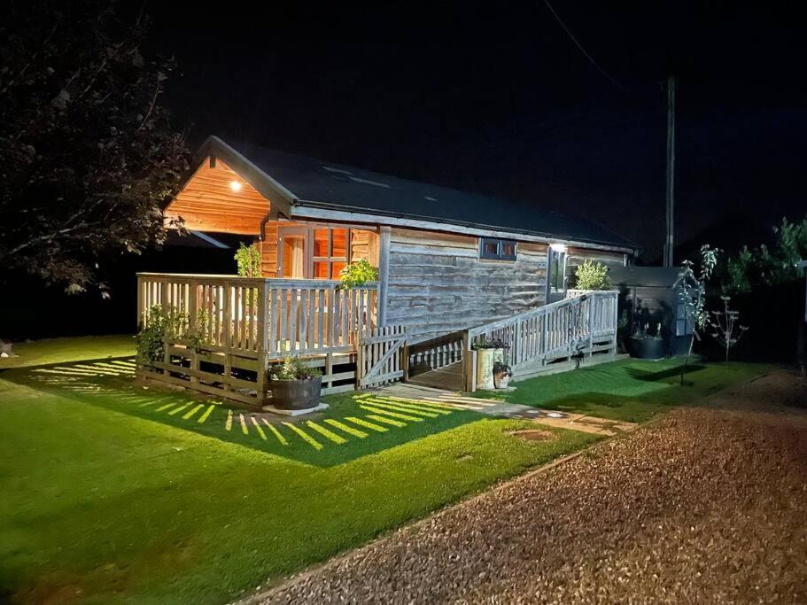 a small cabin with a porch at night at The Firkin Lodge in Whaplode