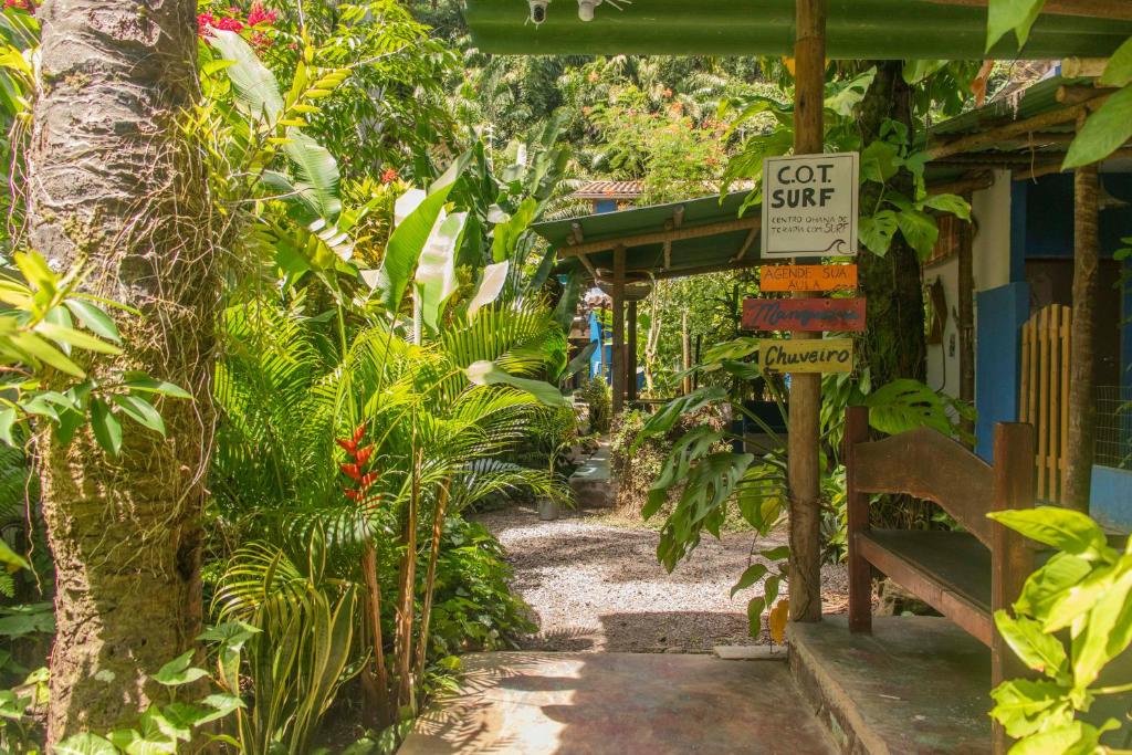 a dirt path in a garden with a outsize sign at Villa Residencial Encantos Da Mata in Itacaré