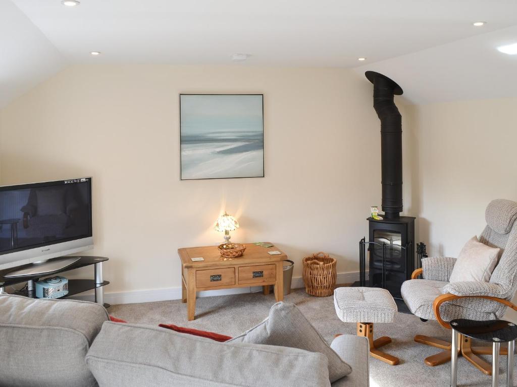 a living room with a couch and a stove at Knights Den in Port Isaac