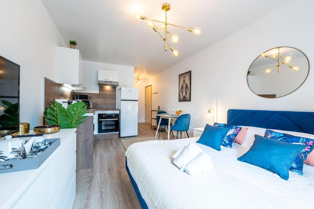 een woonkamer met een bed en een keuken bij Proche Technopole: lit double - fibre - lave-linge in Grenoble