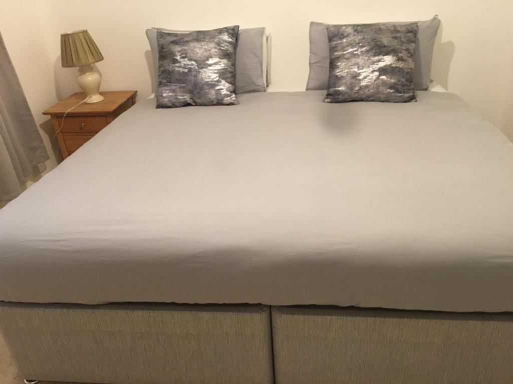 een groot bed met twee kussens erop bij Smarty Angel in Bournemouth