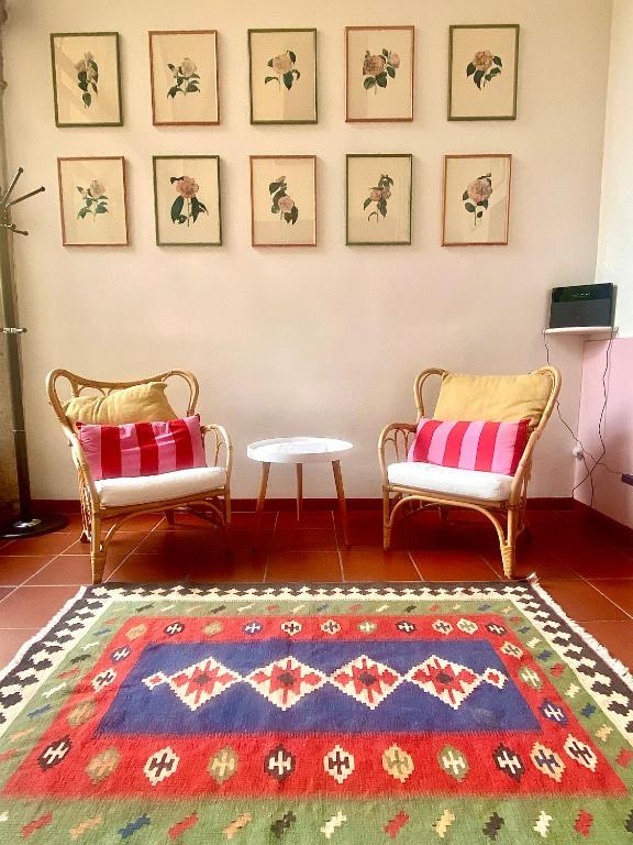 a living room with two chairs and a rug at Cozy Corner in Brescia Center - Dogeshouse in Brescia