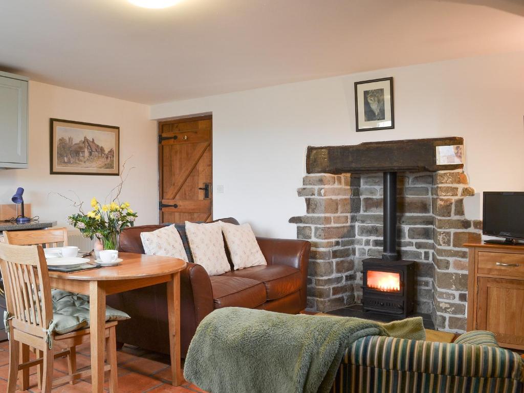 a living room with a couch and a fireplace at Gardeners Cottage - Ukc4299 in Littleham