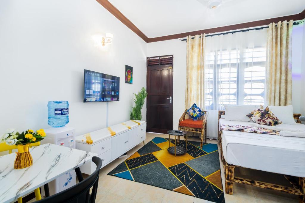 a living room with a bed and a dining room at Shikamoo Spacious Studio Nyali in Mombasa