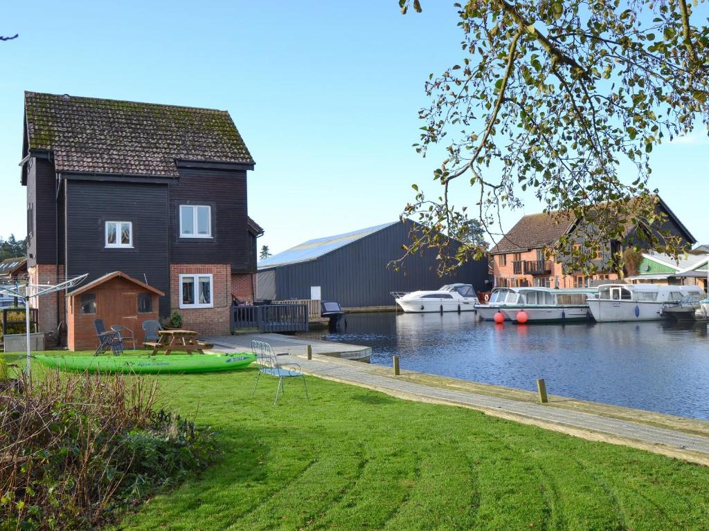 a house on a river with boats in the water at Davids Island in Wroxham