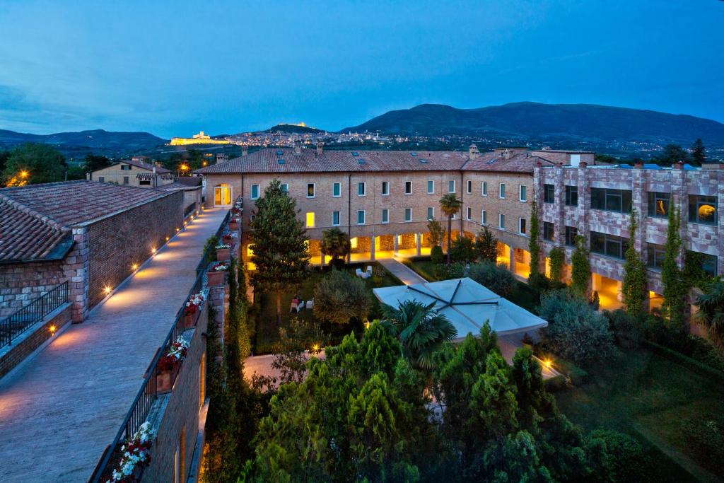 una vista aerea di una città di notte di TH Assisi - Hotel Cenacolo ad Assisi