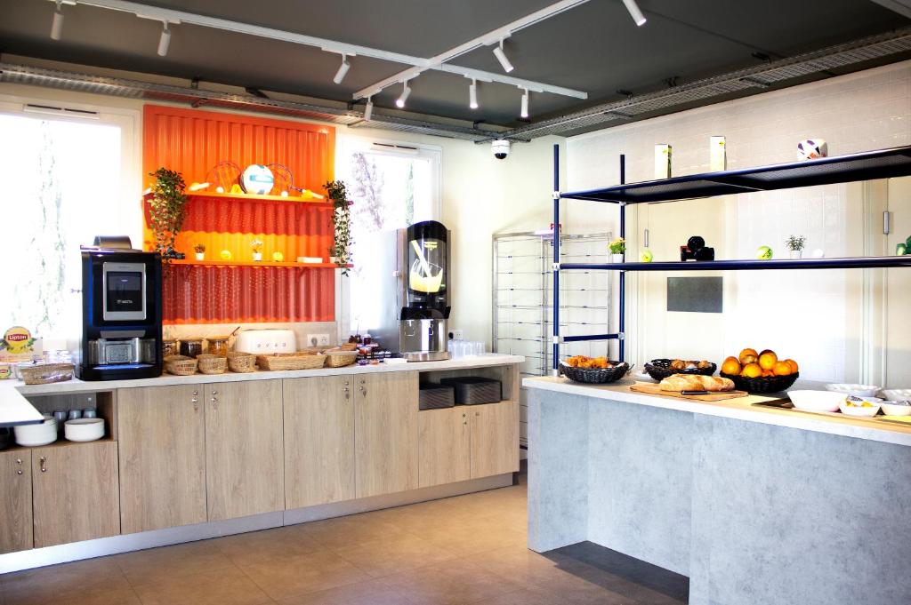 - une grande cuisine avec un comptoir avec des fruits dans l'établissement ibis budget Lunel Porte de Camargue, à Aimargues