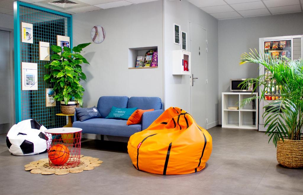 - un salon avec un canapé et un sac jaune dans l&#39;établissement ibis budget Lunel Porte de Camargue, à Aimargues