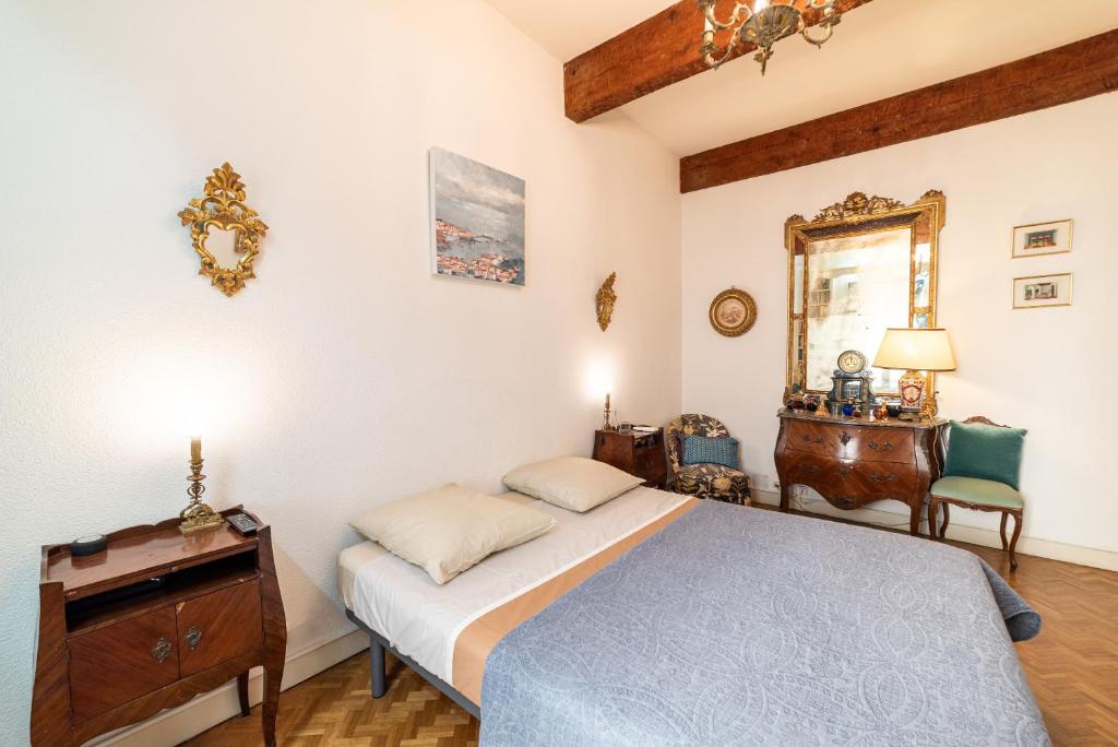 a bedroom with a bed and a dresser and a mirror at Michelet in Collioure