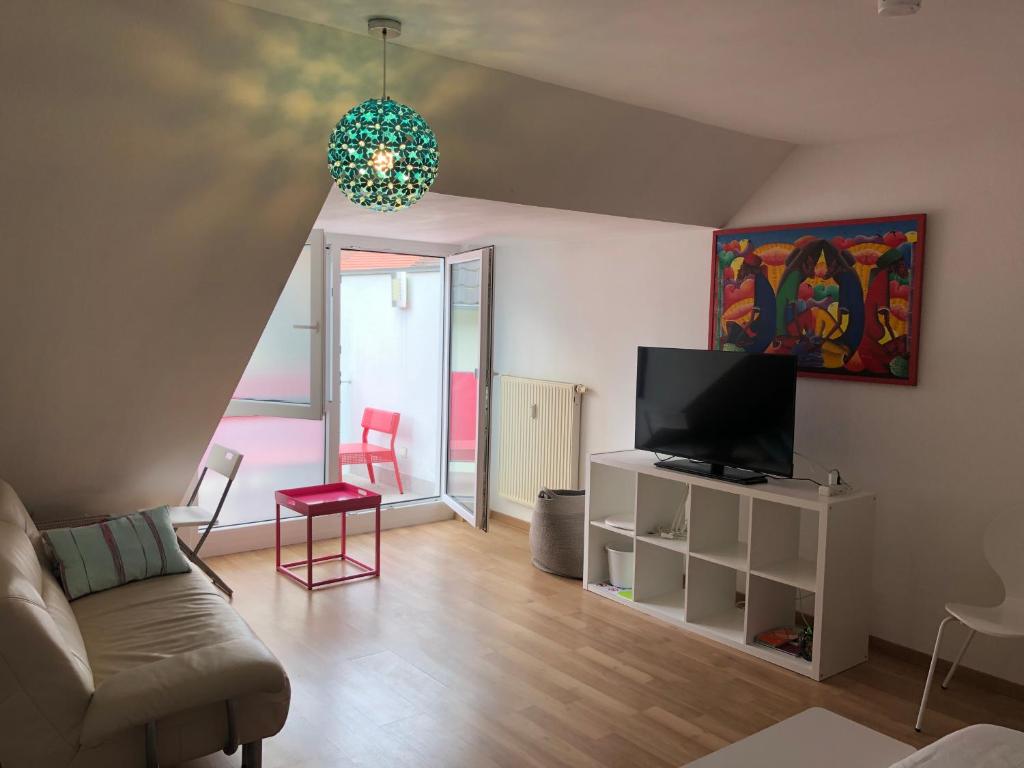 ein Wohnzimmer mit einem Sofa und einem TV in der Unterkunft Studio Ochsenfurt mit sonnigem Balkon in Ochsenfurt