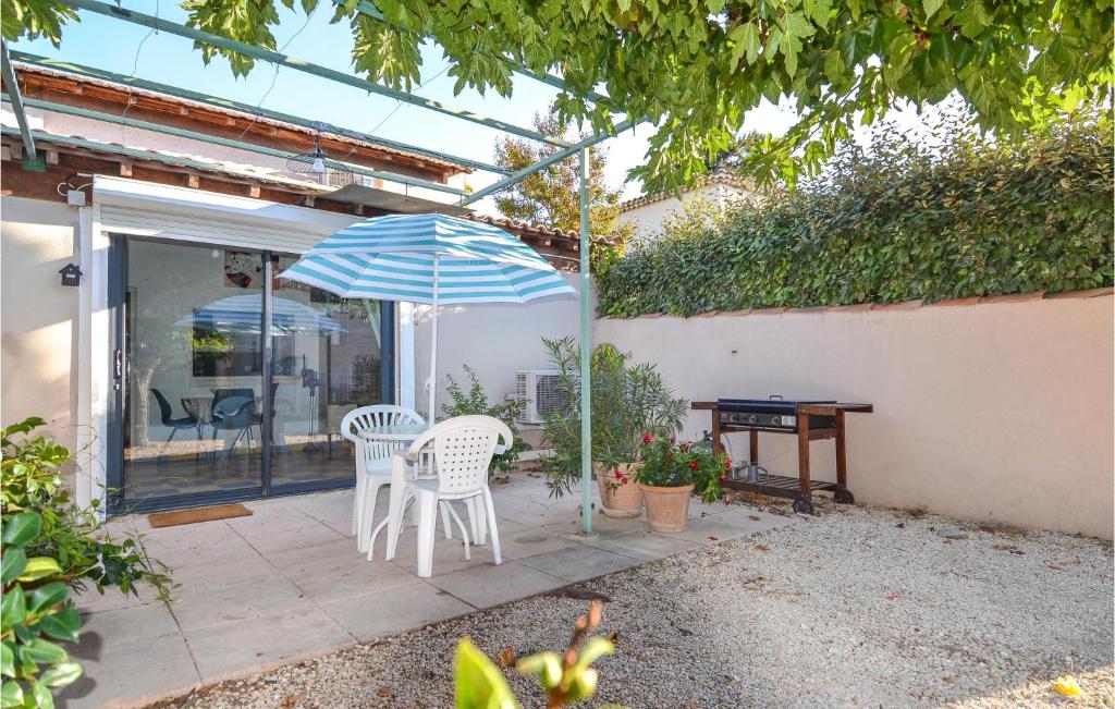 - une terrasse avec 2 chaises, un parasol et une table dans l'établissement 1 Bedroom Beautiful Home In Mouris, à Mouriès