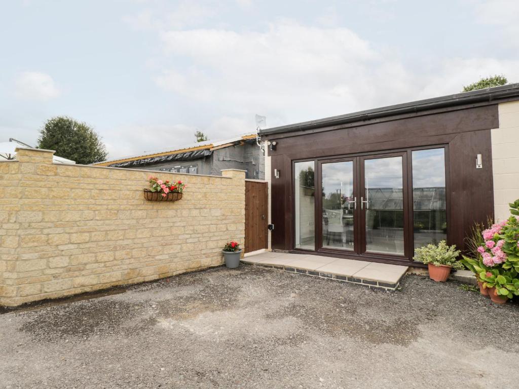 a house with glass doors and a brick wall at The Penthouse, Strawberry Hill Vineyard in Newent