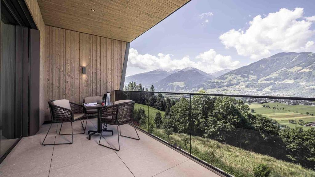 a balcony with a table and chairs and a view of mountains at Panorama Eagle Lodge in Hart im Zillertal