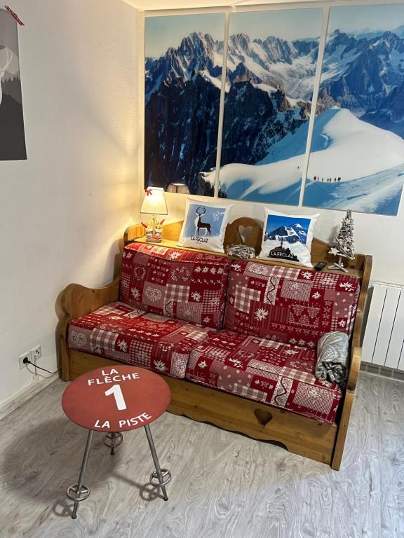 a couch in a room with a picture of a mountain at Studio Croix du berger in La Féclaz