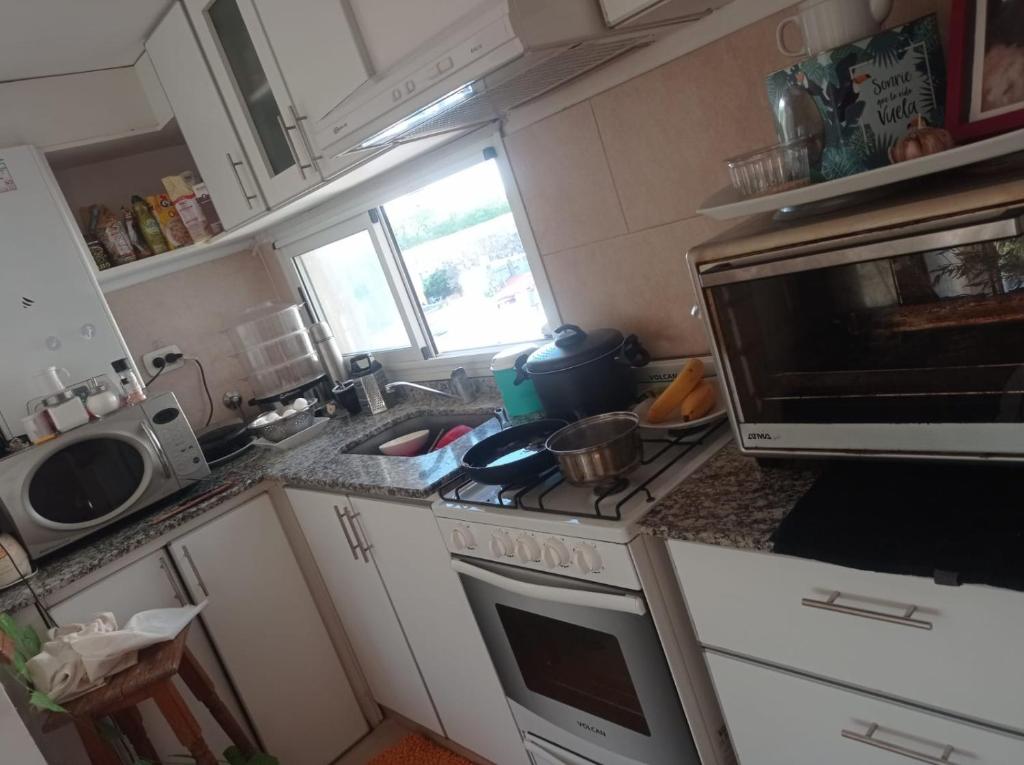 cocina con fregadero y fogones horno superior en departamento céntrico en San Pedro