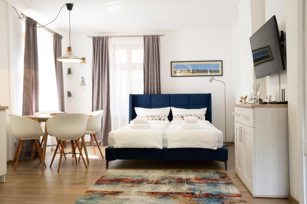 a bedroom with a blue bed and a table and chairs at Transylvanian Valley in Sibiu