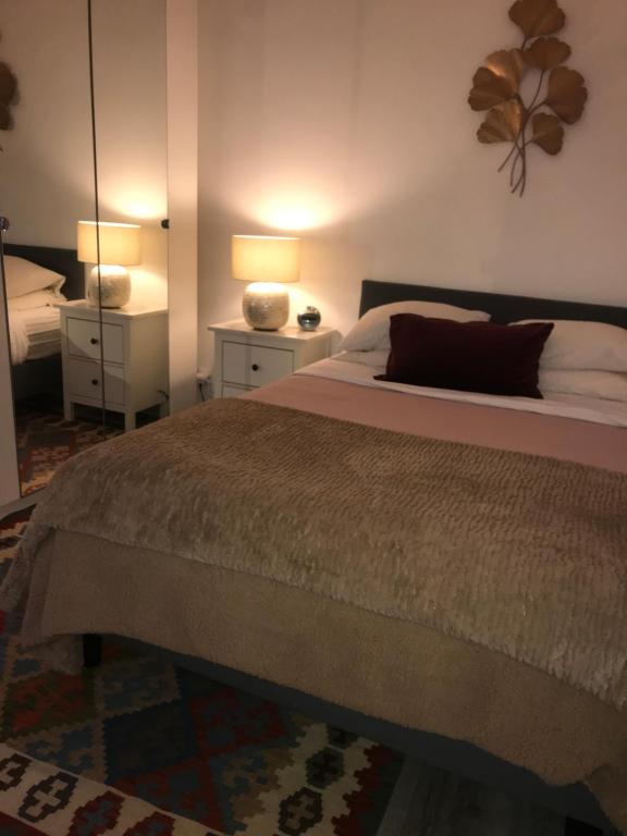 ein Schlafzimmer mit einem Bett mit zwei Lampen und einem Spiegel in der Unterkunft Saint Mandé Paris in Saint-Mandé