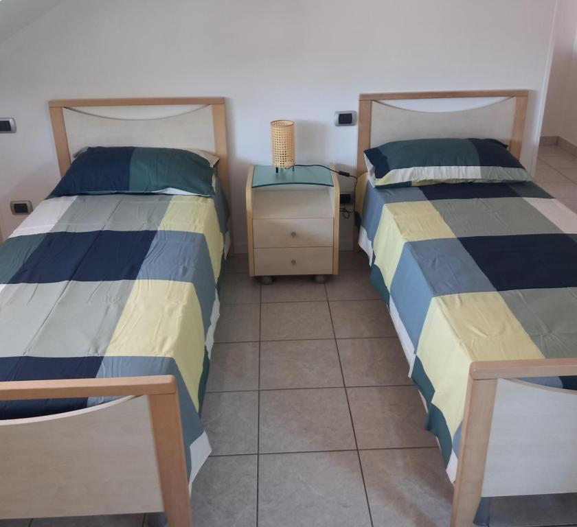 2 Betten nebeneinander in einem Zimmer in der Unterkunft Romano's House in Castel di Lama