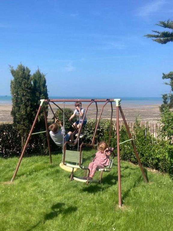 a group of people playing on a swing at Manava Villa vue mer et Mont Saint Michel piscine intérieure in Saint-Jean-le-Thomas