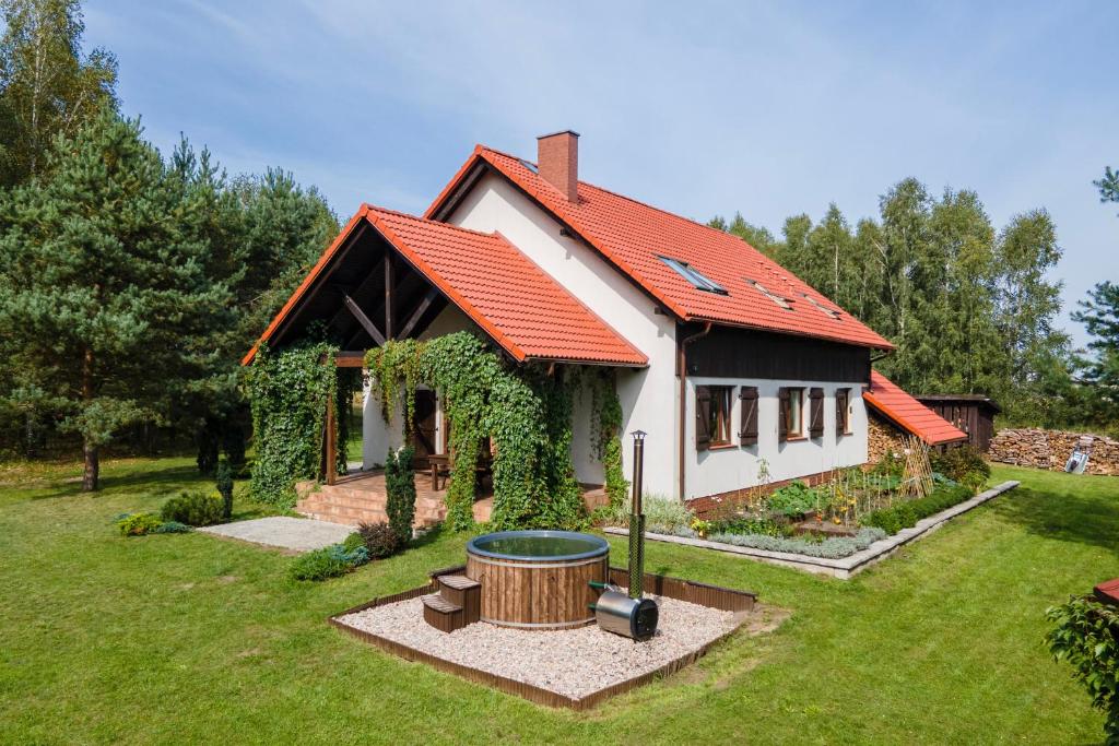a small white house with an orange roof at Przytulisko Stara Kiszewa in Stara Kiszewa