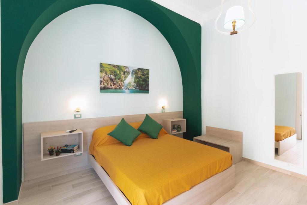 a bedroom with a yellow bed and a green wall at Garden View Sorrento in Sorrento