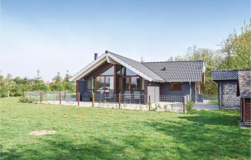 une petite maison avec une clôture dans une cour dans l'établissement Beautiful Home In Skjern With Wifi, à Stavning