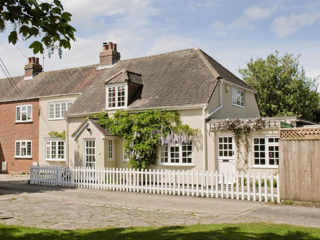 a white fence in front of a house at The Bothy in Lymington