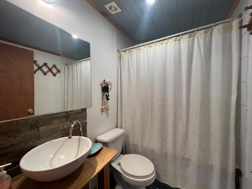 uma casa de banho com um lavatório branco e um WC. em Hamilton's Place Bed and Breakfast em La Ensenada