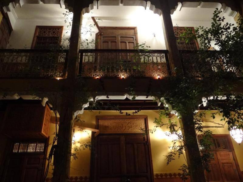 een gebouw met een balkon en een deur met verlichting bij Ryad Nour Al Janoub in Marrakesh