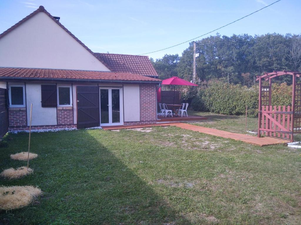 a house with a yard with a fence and a gate at La Tanière des Pandas in Chabris