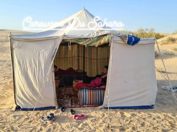 a man sitting in a tent on the beach at Private Camp25km-from DOUZ in Douz
